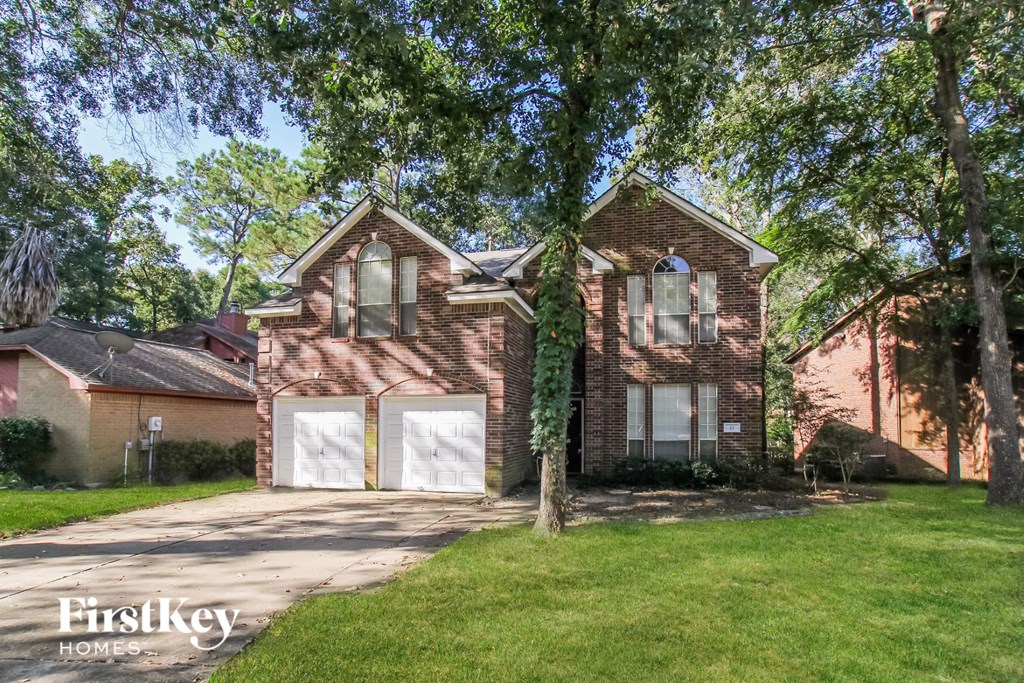 a brick house with two white garage doors