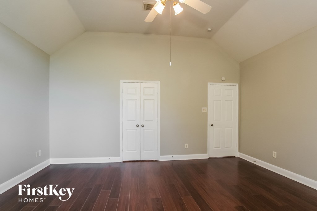 the living room with two doors and a ceiling fan