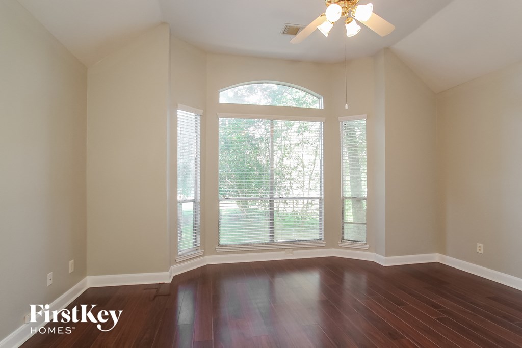 a living room with a large window and wooden floors