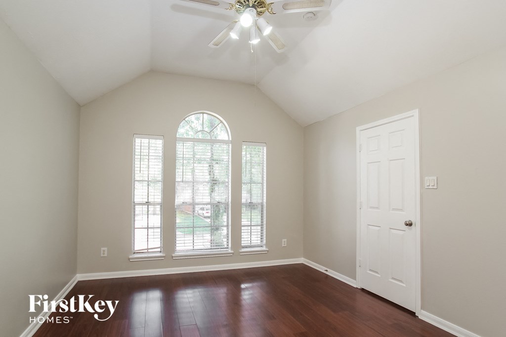 an empty living room with a large window and a white door