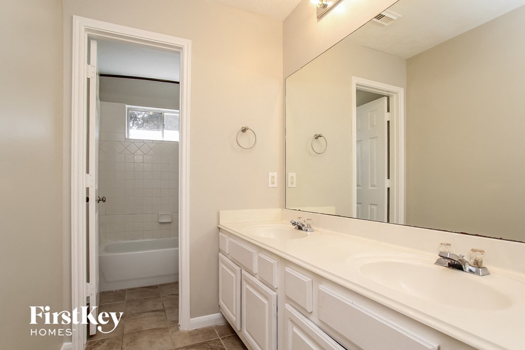 a bathroom with a large mirror and a sink and a shower