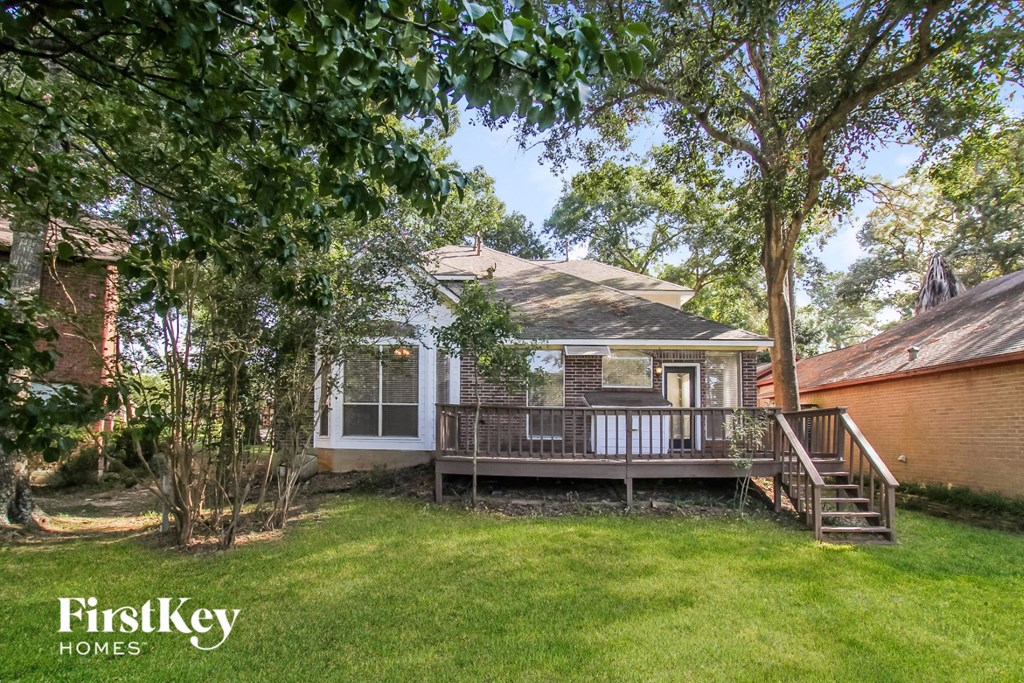 a backyard with a house and a deck and trees