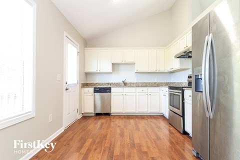 a kitchen with white cabinets and stainless steel appliances