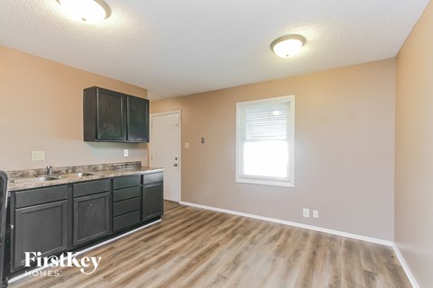 A kitchen with wooden floors and a black countertop.