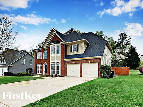 a large brick house with a garage and a lawn