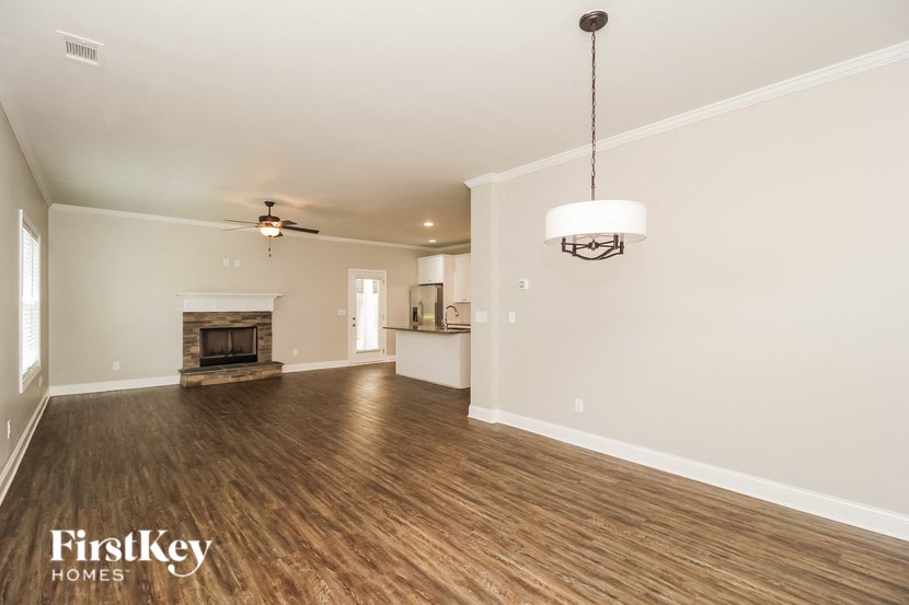 A spacious room with wood flooring and a fireplace is on the market with FirstKey Homes.