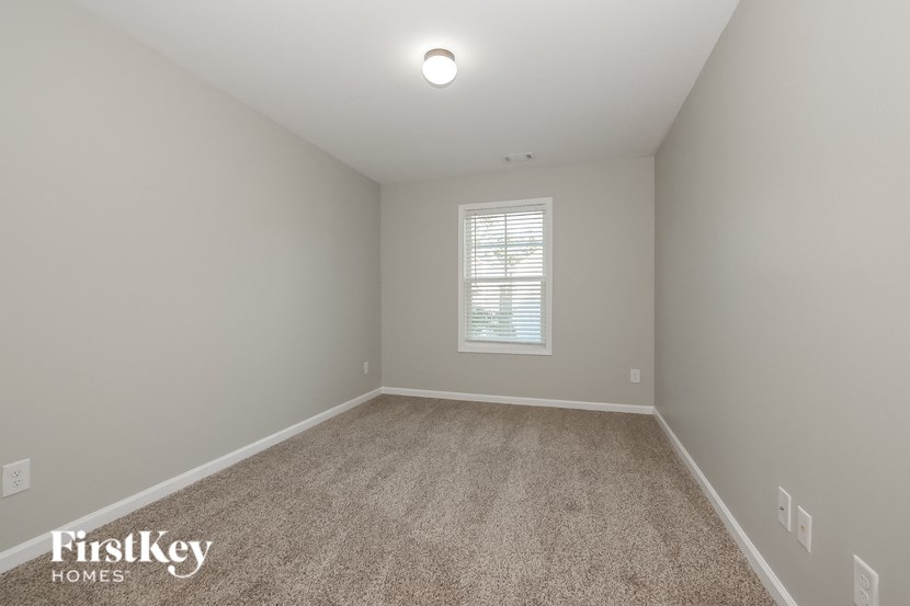 the second bedroom is spacious and clean with carpet and a window