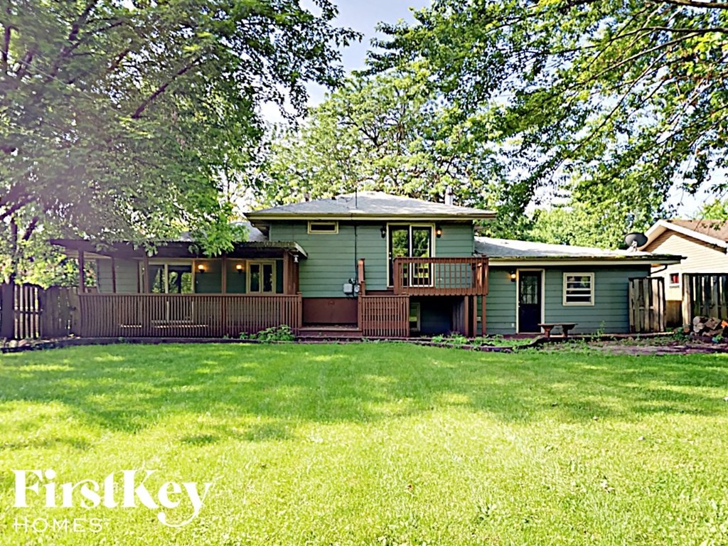 a green house with a yard and a wooden fence