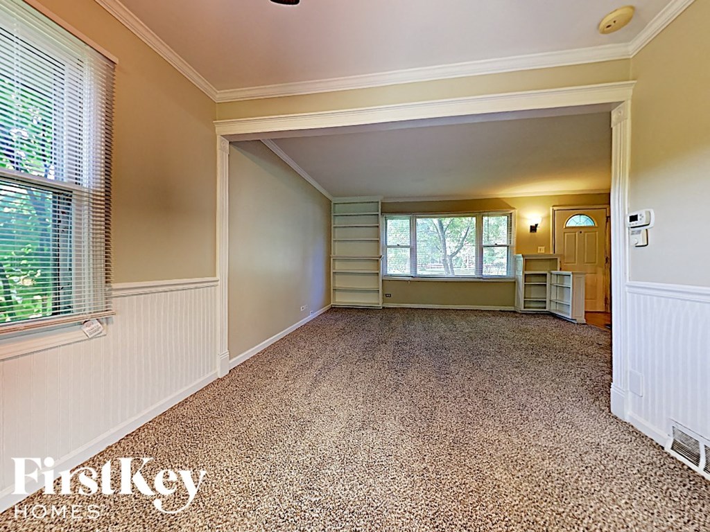 an empty living room with a window and a radiator