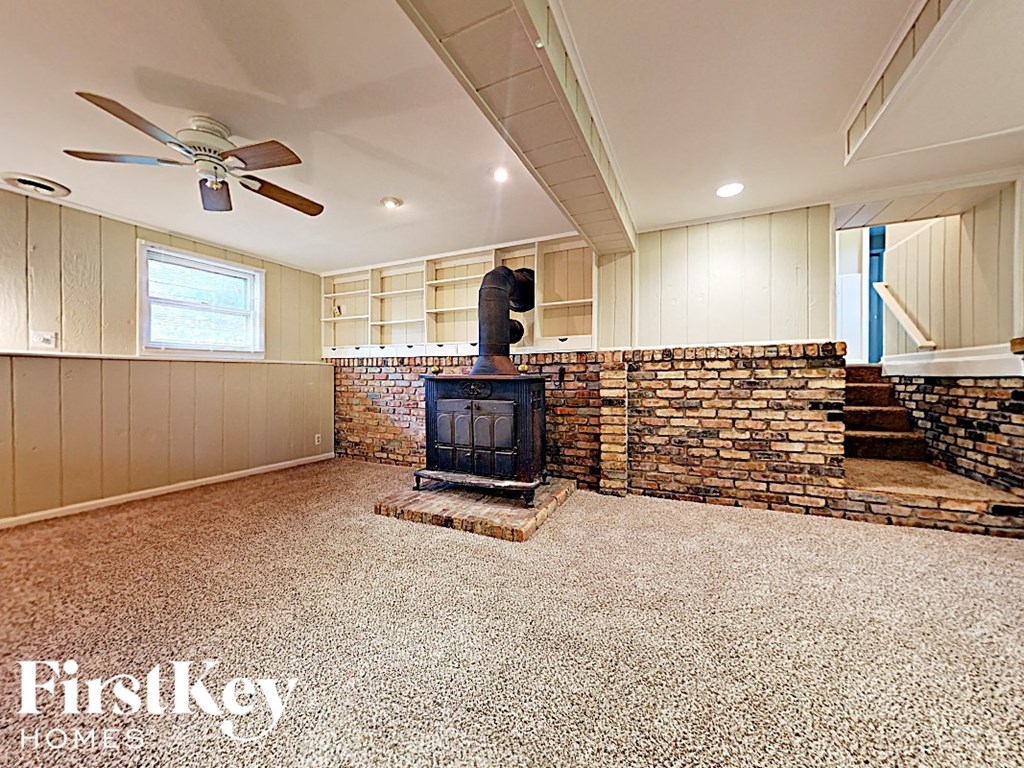 a wood stove in a living room with a brick fireplace