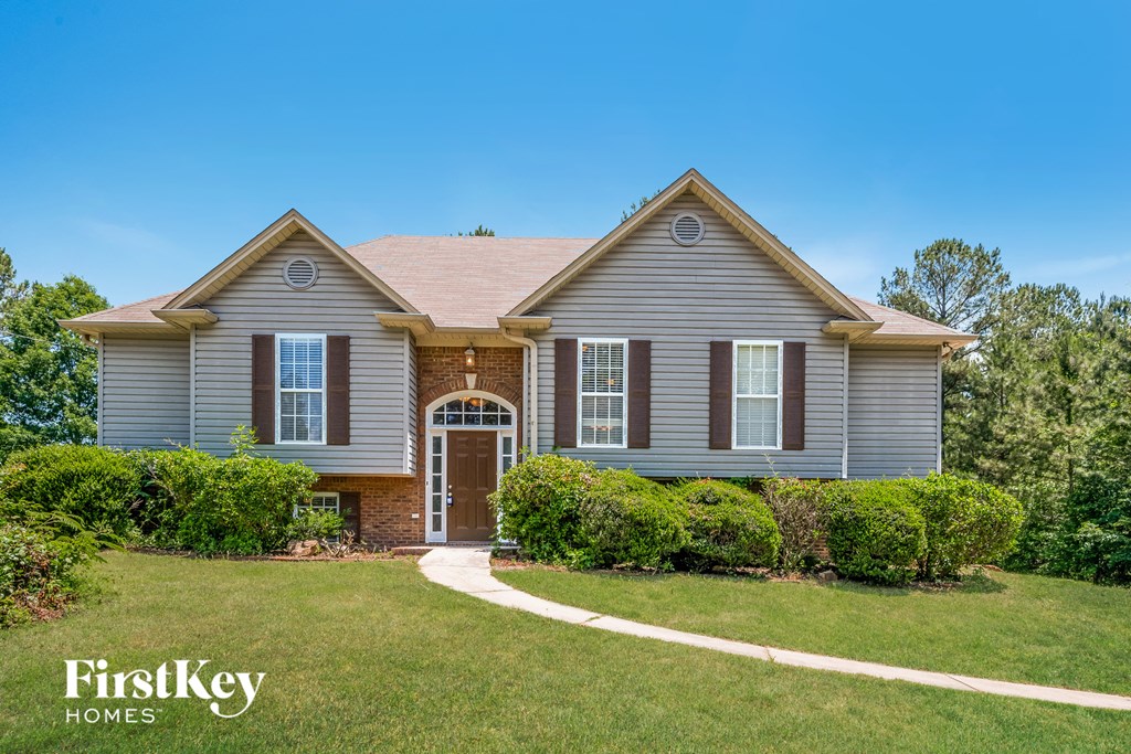 a home with a lawn and a sidewalk in front of it
