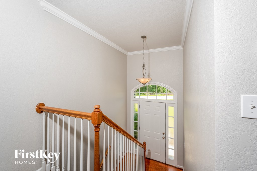 a landing with a staircase and a white door with a window