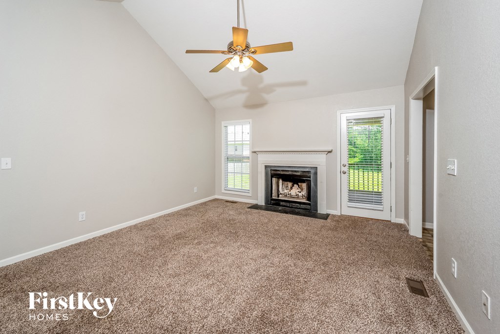 the living room has a fireplace and a ceiling fan