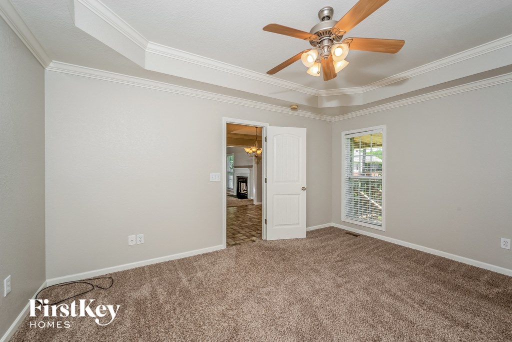 a living room with carpet and a ceiling fan