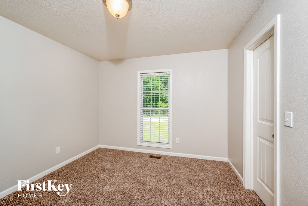 an empty room with carpet and a window