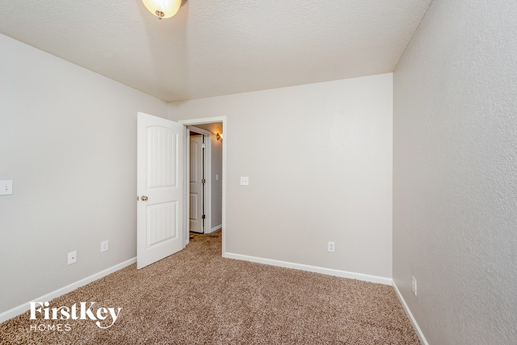 a bedroom with carpet and a door to a closet