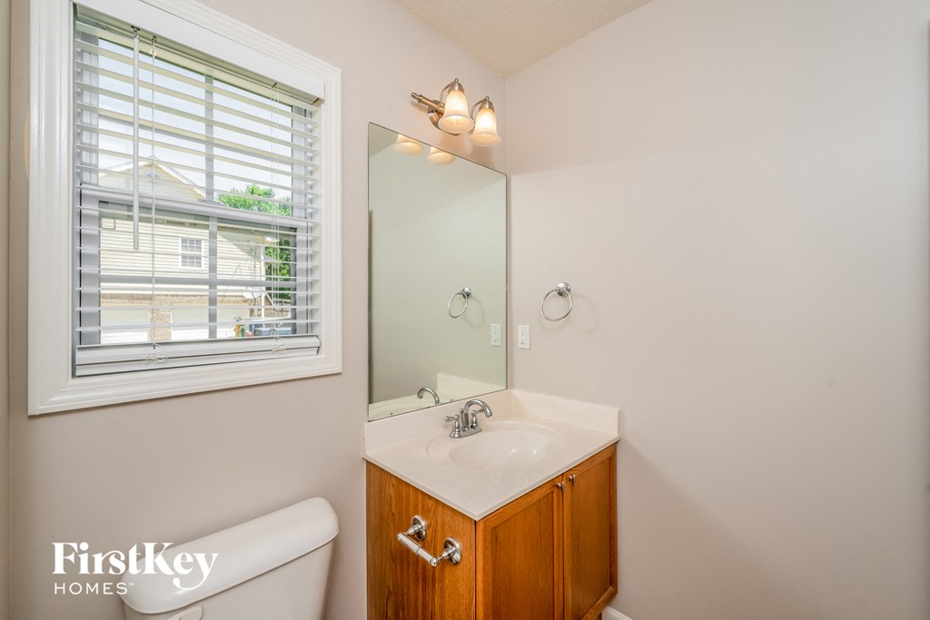 a bathroom with a sink and a mirror and a window