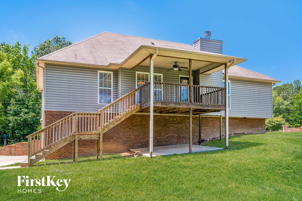 a house with a deck and a porch on a lawn