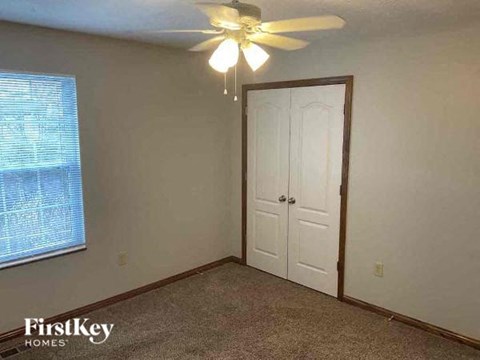 A room with a ceiling fan and a door.