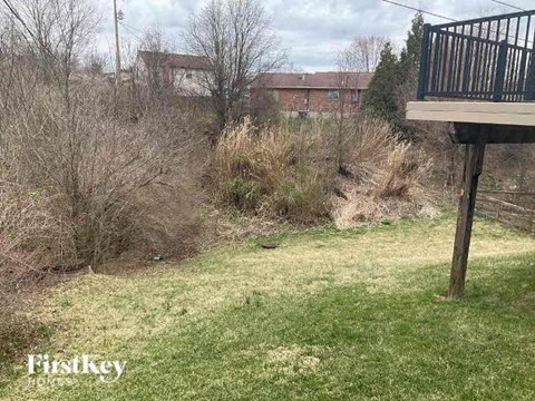 A backyard with a deck and a grassy area.