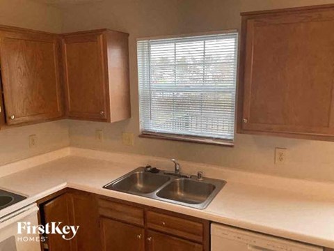 A kitchen with wooden cabinets and a double sink.