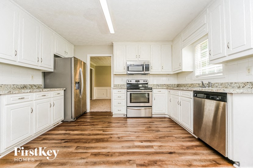 a kitchen with white cabinets and stainless steel appliances