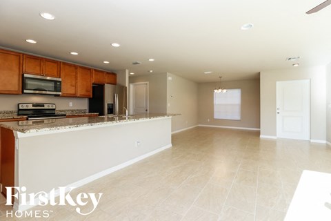 A kitchen with wooden cabinets and a tiled floor.