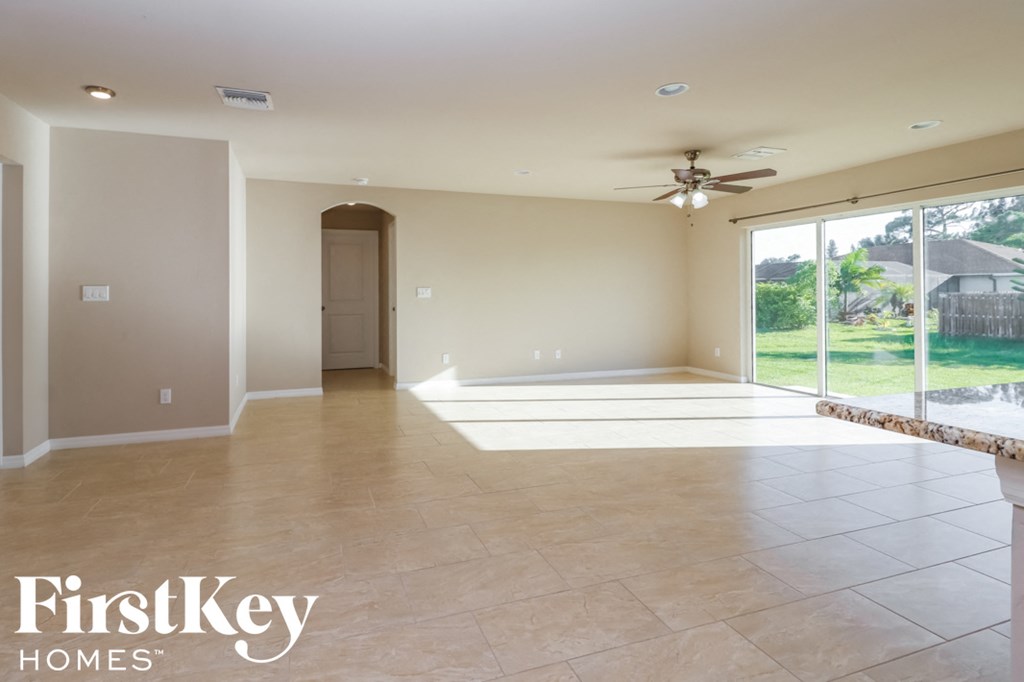 A spacious room with a ceiling fan and sliding glass doors.