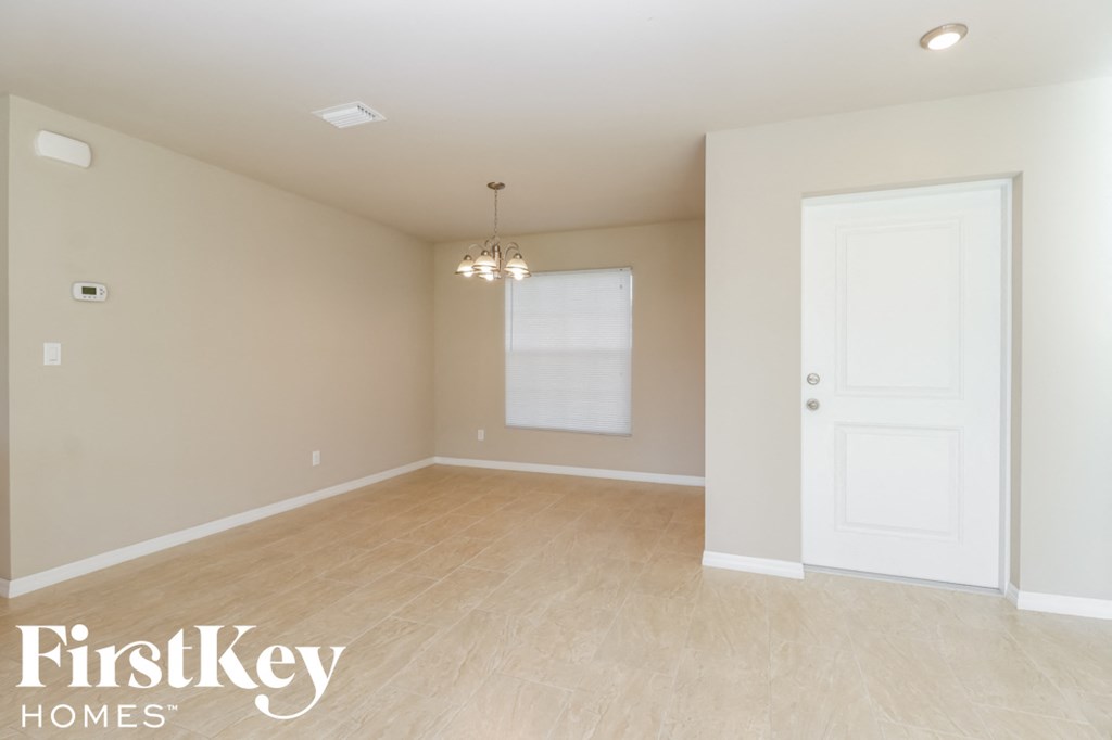 A room with a white door and a window with blinds.