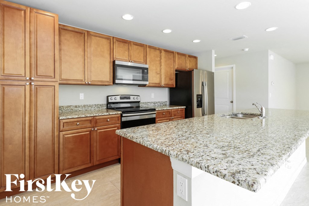 A kitchen with granite countertops and wooden cabinets.