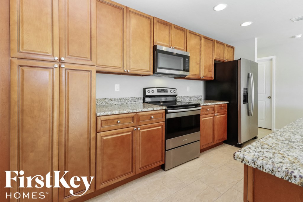 A kitchen with wooden cabinets and granite countertops.