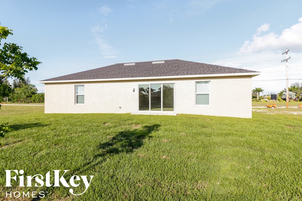 A white house with a brown roof and a sign that says FirstKey Homes.