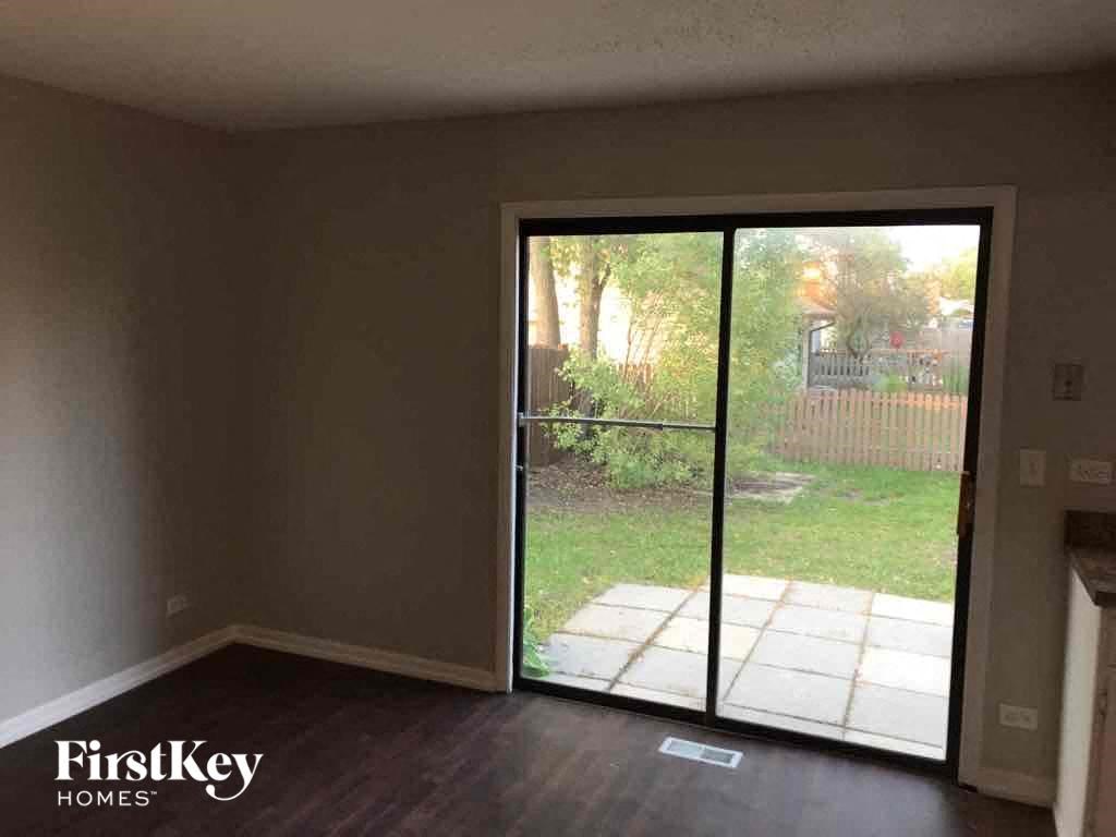A room with a sliding glass door leading to a backyard.