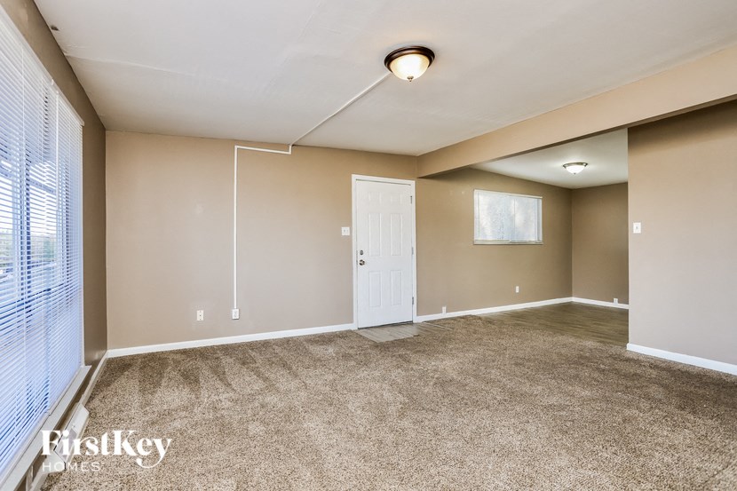 A room with a carpeted floor and a white door.