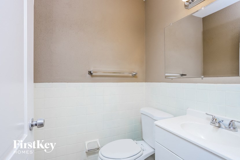 A white toilet sits next to a white sink in a small bathroom.