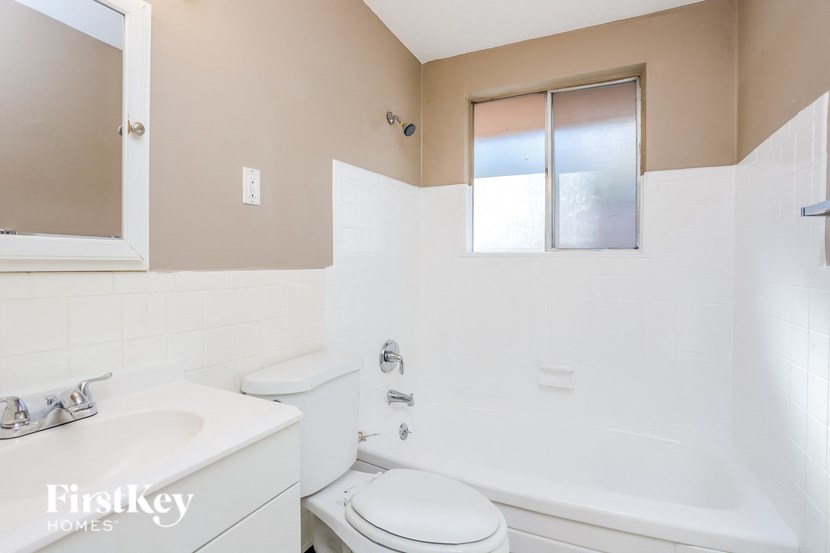 A white toilet sits next to a sink in a bathroom.