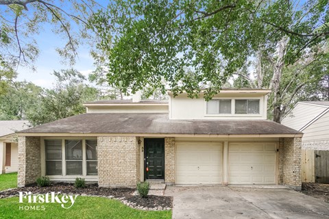 a white brick house with a large tree in front of it