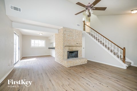 a living room with a fireplace and a ceiling fan