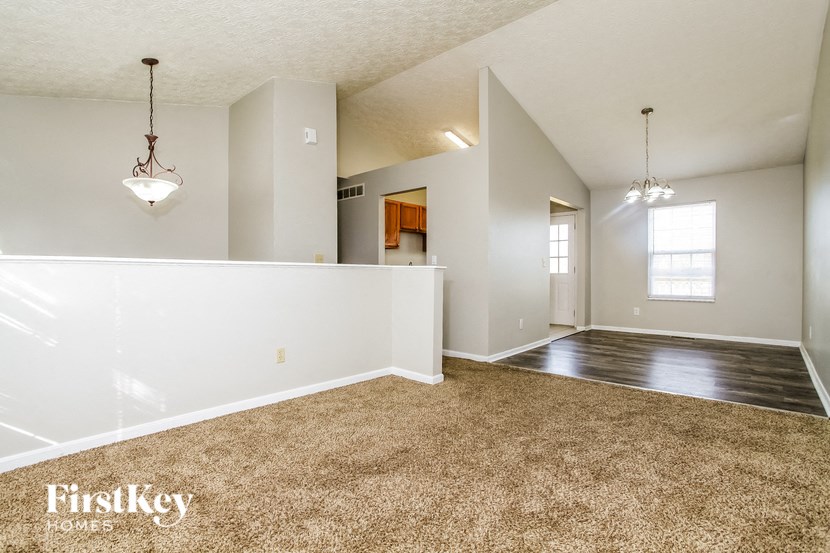 the living room and dining room of an empty house