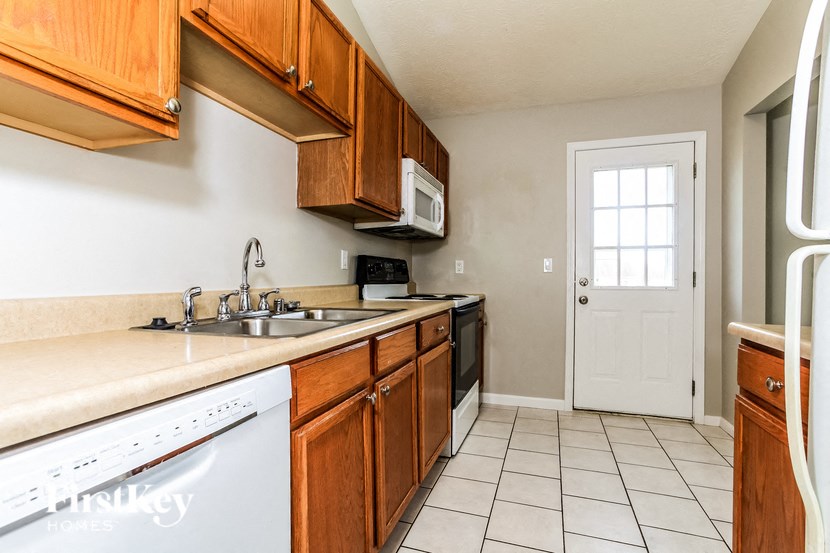a kitchen with wooden cabinets and a sink and a dishwasher