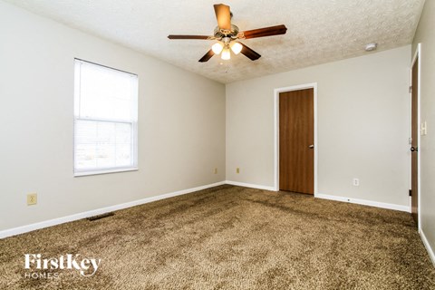 a living room with carpet and a ceiling fan