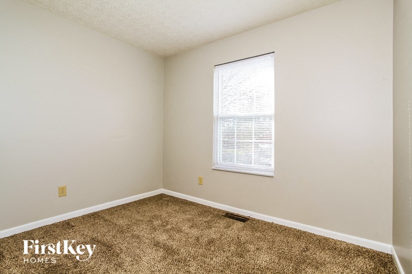 a bedroom with a carpeted floor and a window