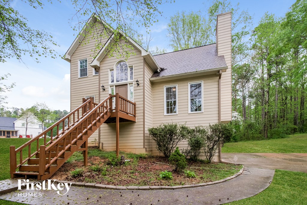 a home with a wooden deck and a staircase