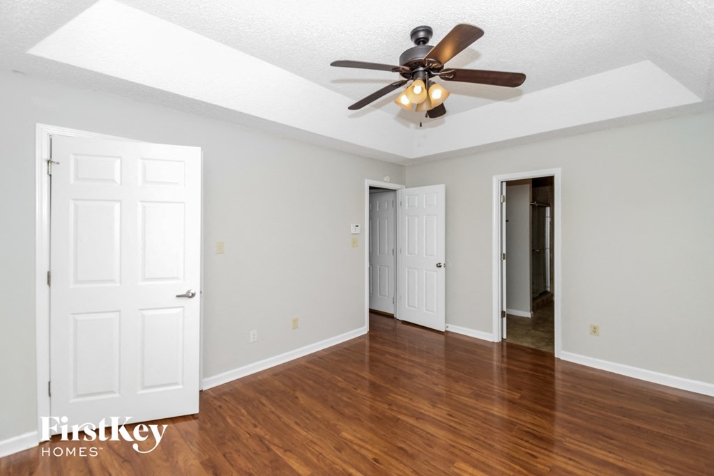 the living room of an empty house with a ceiling fan