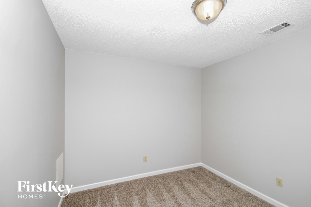 a bedroom with a carpeted floor and white walls