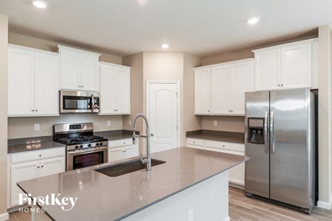 A kitchen with white cabinets and stainless steel appliances.