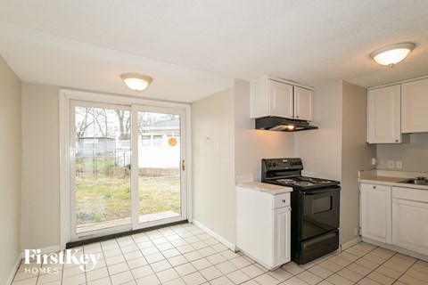 A kitchen with a black stove top oven and white dishwasher.