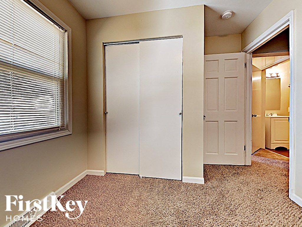 a bedroom with a closet and a window and a door