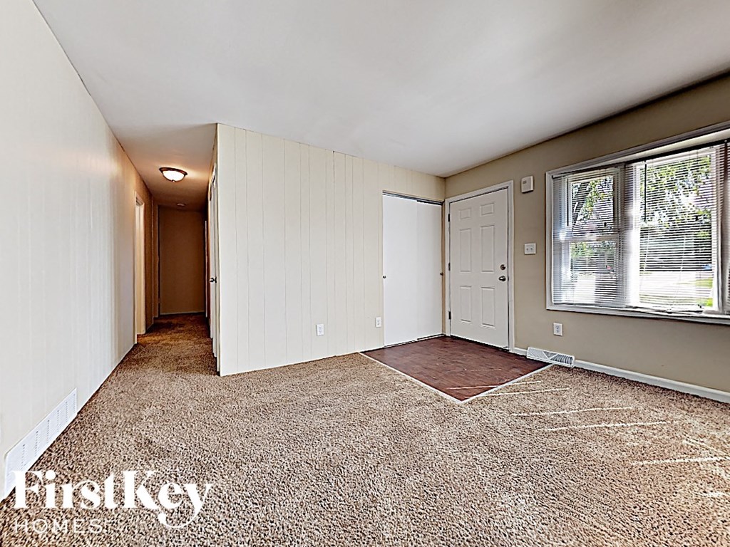 an empty bedroom with a window and a door