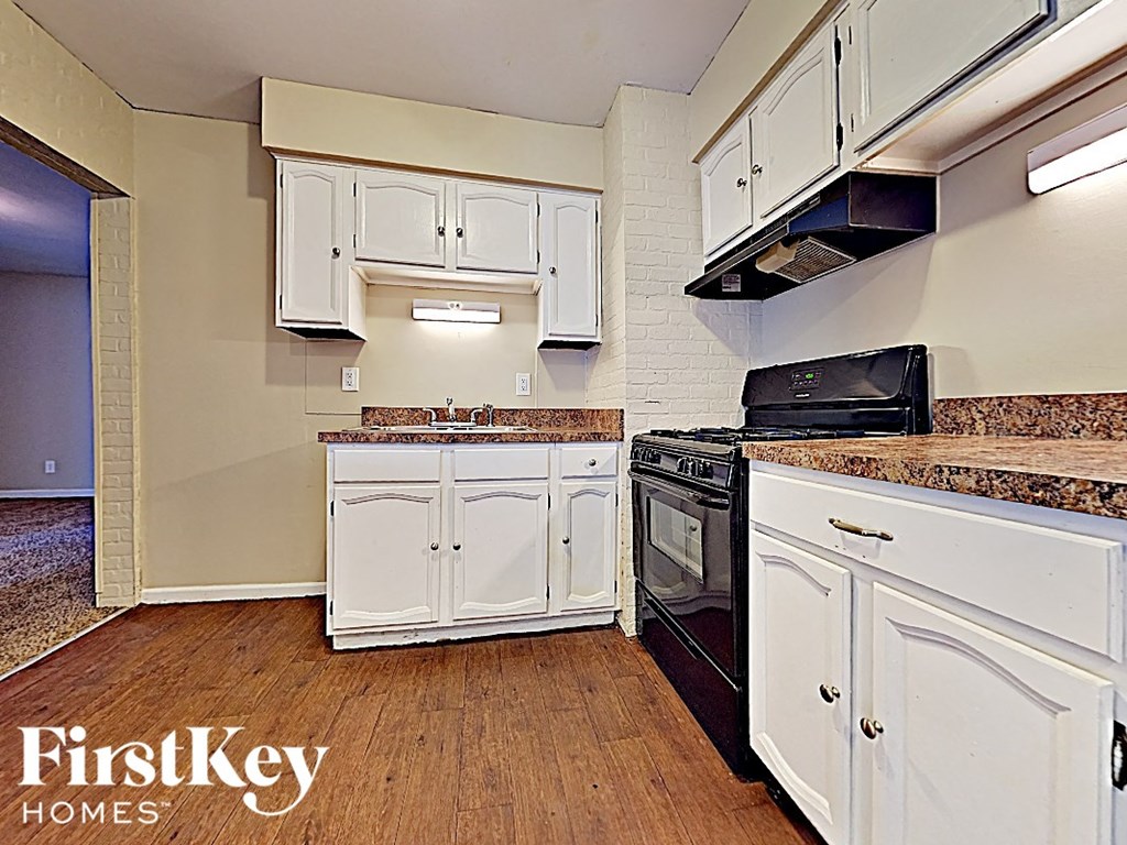 a kitchen with white cabinets and a stove top oven